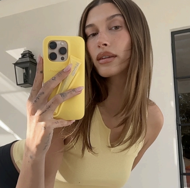 Rhode lip gloss and phone case holder on a pastel background